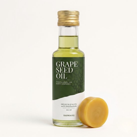 Glazen fles met gele druivenpitolie en een rond geel blok bijenwas.