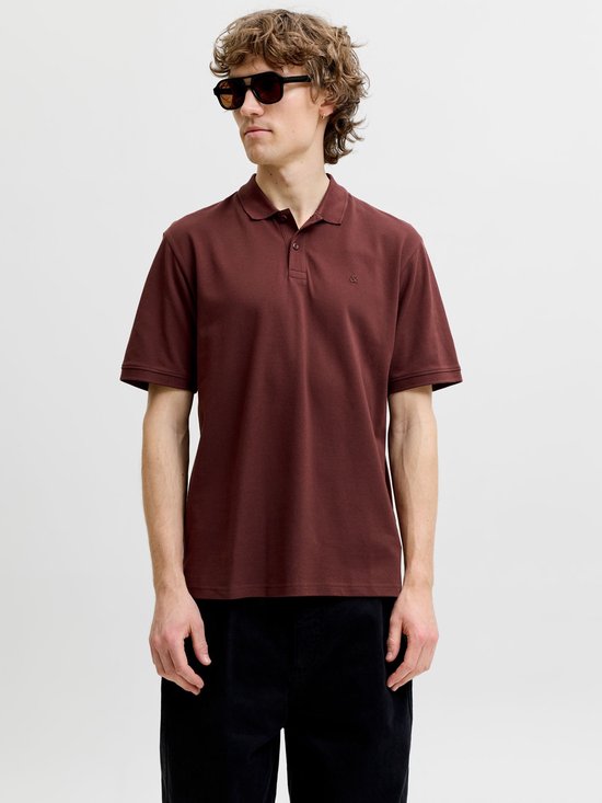Man in een donkerbruine polo met geborduurd logo