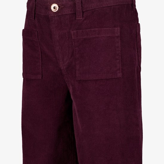 Detail van donkerrode corduroy broek met wijde pijpen, met opgestikte zakken.