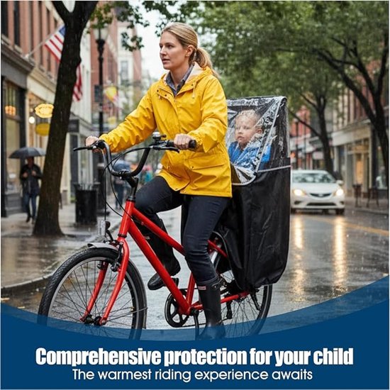 Vrouw in gele regenjas op rode fiets met kind in zwarte regenhoes, rijdend in de regen.