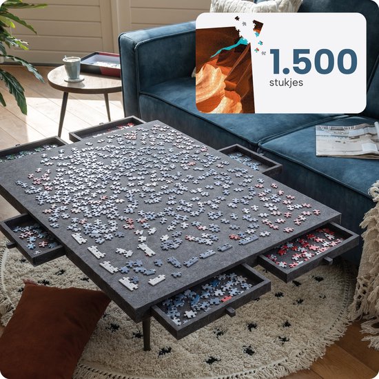 Grijze vilten puzzelplaat voor 1500 stukjes met uitgeschoven lades, staand op een salontafel.