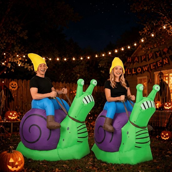 Een man en een vrouw in opblaasbare slakkenkostuums zitten buiten bij nacht, met Halloween-decoraties.