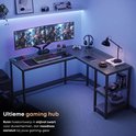 Stijlvol zwart L-vormig bureau met LED-verlichting, dubbele monitorstandaard, toetsenbord, muis en gameconsole.