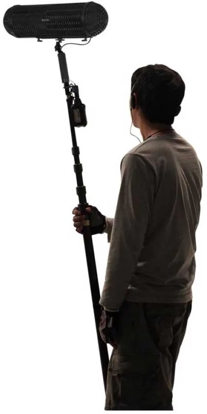 Man met microfoonstok met windkap, in grijze trui en cargo broek.