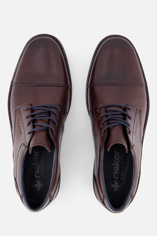 Bovenkant van bruine leren veterschoenen van Rieker met donkerblauwe veters en zool.