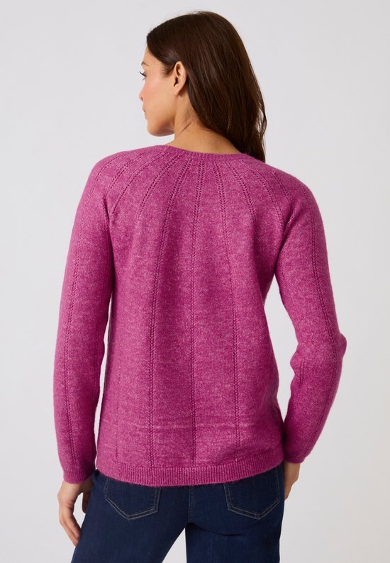 Roze gebreide trui met ronde hals en open details, versierd met gouden speldjes op de schouders.