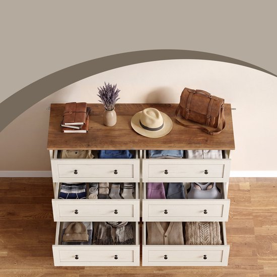 Commode blanche à 6 tiroirs ouverts remplis de vêtements et accessoires. Plateau en bois avec décoration.