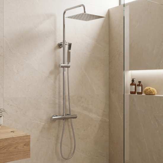 Een moderne doucheopstelling in een lichte badkamer, met een chromen thermostaatkraan, hoofddouche, handdouche en glazen douchewand.
