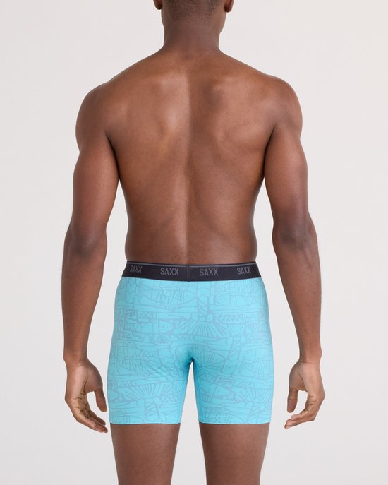 Man van achteren gezien in lichtblauwe boxershort met grijze print en zwarte SAXX-band.