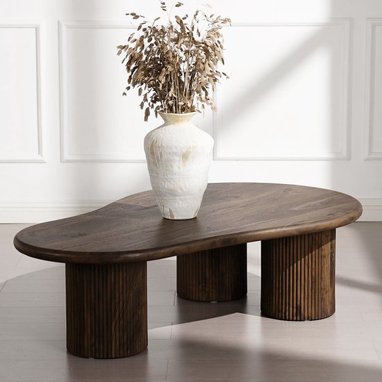 Donkerbruine, organische salontafel met geribbelde poten, met vaas en gedroogde planten.