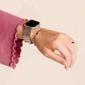 Een vrouw draagt een zilverkleurig metalen smartwatchbandje om haar linker pols.