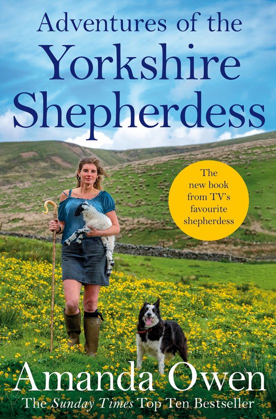 Boekcover van 'Adventures of the Yorkshire Shepherdess' met Amanda Owen die een lam vasthoudt, met een hond en bloemen op een heuvel.