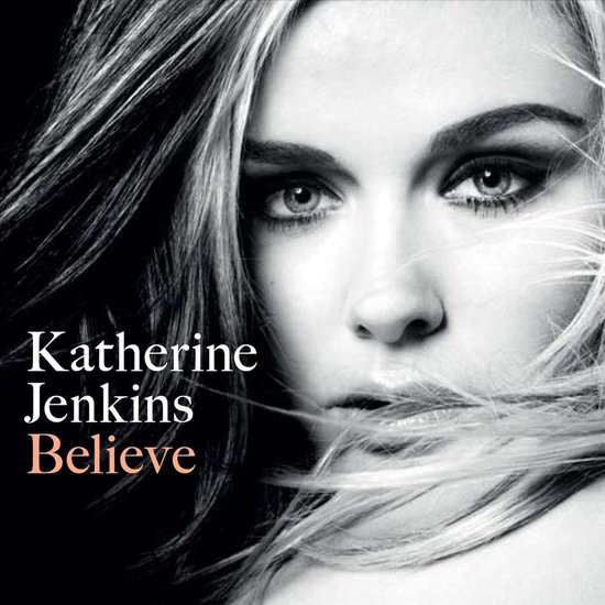 Katherine Jenkins 'Believe' albumhoes met een close-up van haar gezicht en wapperend blond haar. Tekst 'Katherine Jenkins Believe' in wit en oranje.