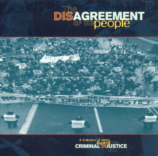 Een menigte op straat met spandoeken waarop staat 'The DISAGREEMENT OF THE people' en 'DEFY CRIMINAL JUSTICE'.