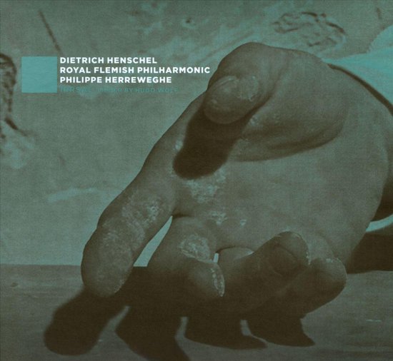 Close-up van een hand met de tekst "DIETRICH HENSCHEL ROYAL FLEMISH PHILHARMONIC PHILIPPE HERREWEGHE IRRSAL LIEDER BY HUGO WOLF".