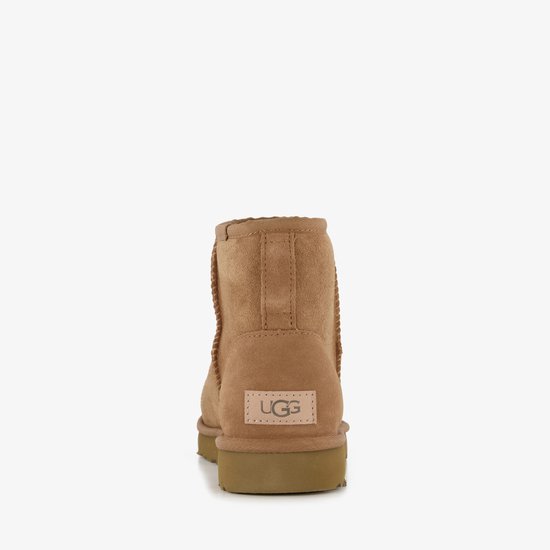 Achterkant van een bruine UGG laars met beige UGG logo label.
