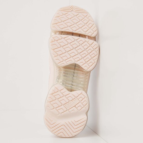 Onderkant van een roze lage sneaker, met profiel en doorzichtige zool.