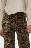 Model in wijde jeans met luipaardprint en gebroken wit trui.