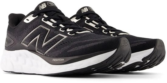 Paar zwarte New Balance sportschoenen met witte zolen, grijze N-logo's en 'Fresh Foam' opdruk.