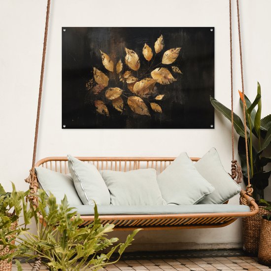 Feuilles dorées sur fond sombre, suspendues au-dessus d'une balançoire en rotin avec coussins clairs, à l'extérieur.