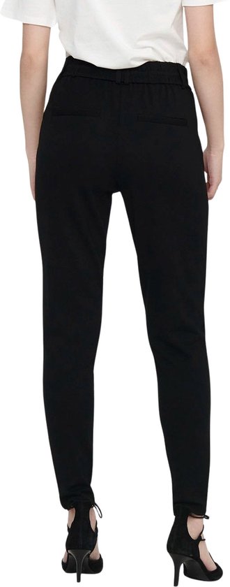 Zwarte broek met hoge taille en ceintuur, gedragen door een model met hoge hakken.