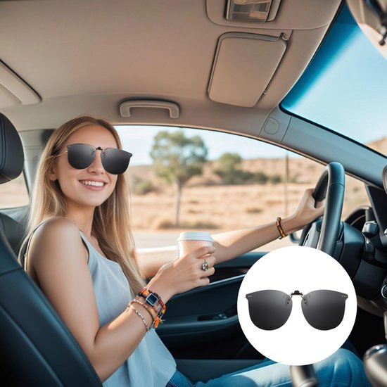 Vrouw met blonde haren in een auto, zonnebril op, met een koffiebeker in haar hand.