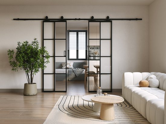 Un salon avec un canapé blanc, deux tables basses et une double porte coulissante avec cadre en acier noir.