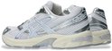 Zijaanzicht van witte ASICS GEL-1130 sportschoenen met zilveren en lichtblauwe accenten.