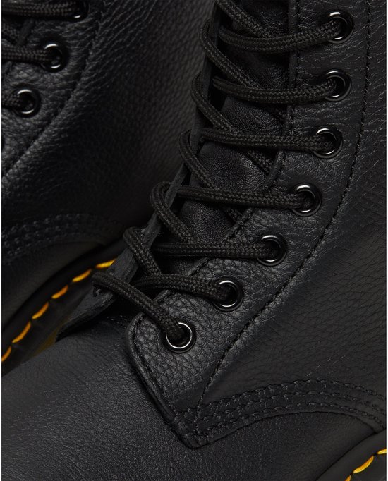 Gros plan des œillets et des lacets d'une botte Dr. Martens noire à lacets.