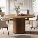 Ronde houten eettafel met geribbeld onderstel, gedekt voor vier personen.
