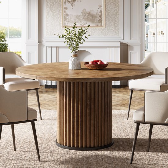 Ronde houten eettafel met geribbeld onderstel, gedekt voor vier personen.