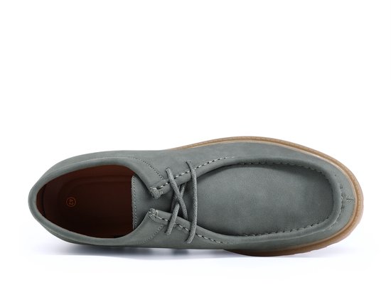 Bovenaanzicht van een grijze suède loafer met vetersluiting en dikke bruine zool.