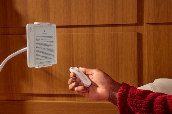 Een hand met een witte Kobo afstandsbediening, houdt deze bij een witte eReader op een standaard.