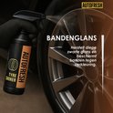 Een hand met een zwarte handschoen spuit bandenglans uit een autofresh fles op een wiel.