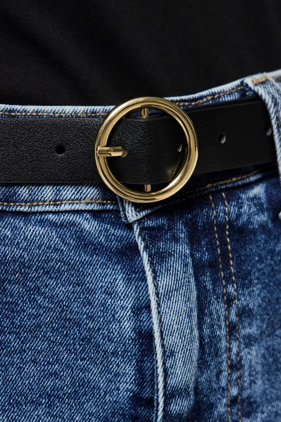 Zwarte riem met goudkleurige gesp, gedragen met een spijkerbroek.