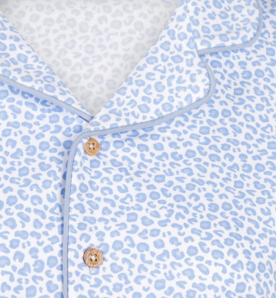 Detail van blauwe pyjamatop met luipaardprint, knopen en bies.