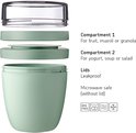 Lichtgroene, uit elkaar gehaalde lunchpot met compartimenten voor fruit en yoghurt.