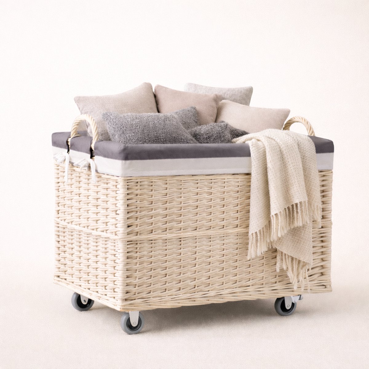 The Wicker Stories – Grote rieten mand op wielen met handgrepen – Handgemaakt van gebleekt riet met versterkte bodem en gris stoffen voering – Ideaal voor was, speelgoed en huishoudelijke accessoires.