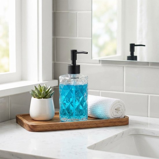Glazen zeepdispenser met zwarte pomp, gevuld met blauwe zeep, op een houten plankje.