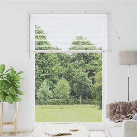 Witte jaloezieën in een woonkamer met uitzicht op groen.