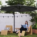 Grote donkergrijze zwevende parasol boven een vrouw die een boek leest op een ligstoel in een tuin.