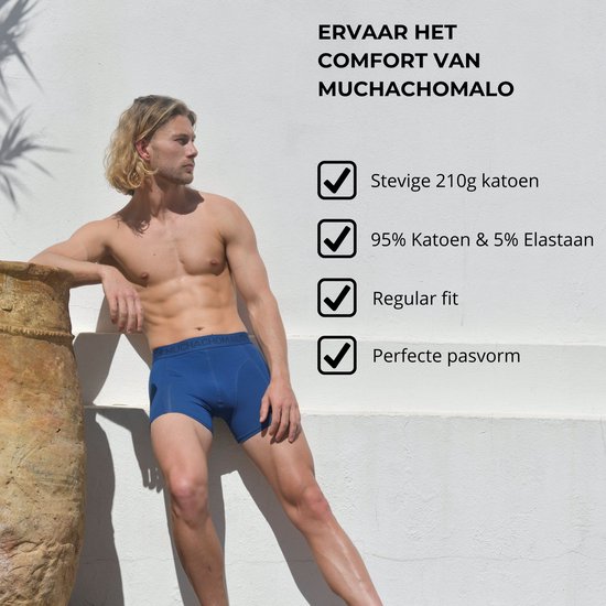 Model in blauwe Muchachomalo boxershort met logo-band, leunend tegen een muur.