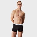 Man met gespierd bovenlichaam draagt een zwarte Calvin Klein boxer met witte logo-tailleband.