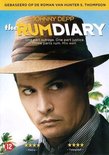 Johnny Depp draagt een fedora met kleurrijke banden, een geruit hemd en kijkt weg. Palmbomen op de achtergrond.
