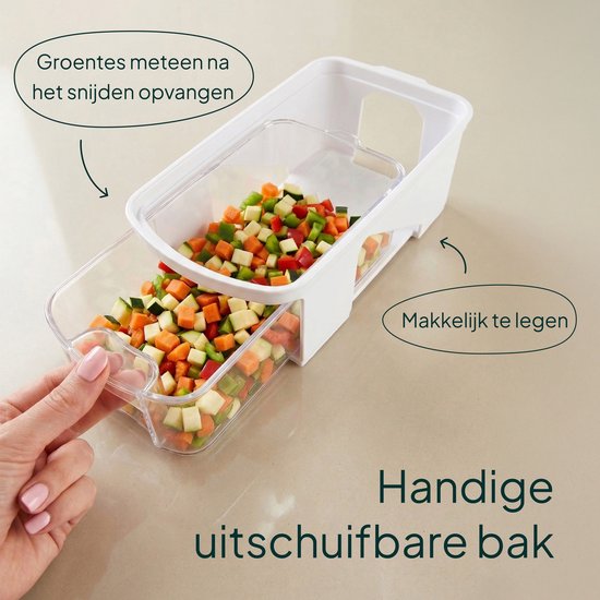 Witte groentesnijder met een uitschuifbare transparante lade gevuld met blokjes gesneden groenten. Groenten worden gemeten na het snijden.