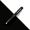 Tweezerman schuin pincet met zwarte glitter, diagonaal geplaatst op een zwart-wit gesplitste achtergrond.