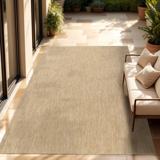 Tapis intérieur/extérieur avec un motif chiné uni dans des tons de brun, à côté d'un canapé sur une terrasse.