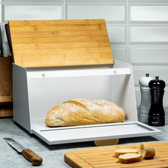 Boîte à pain blanche en métal avec motif diamant, couvercle en bois ouvert. Un pain à l'intérieur.