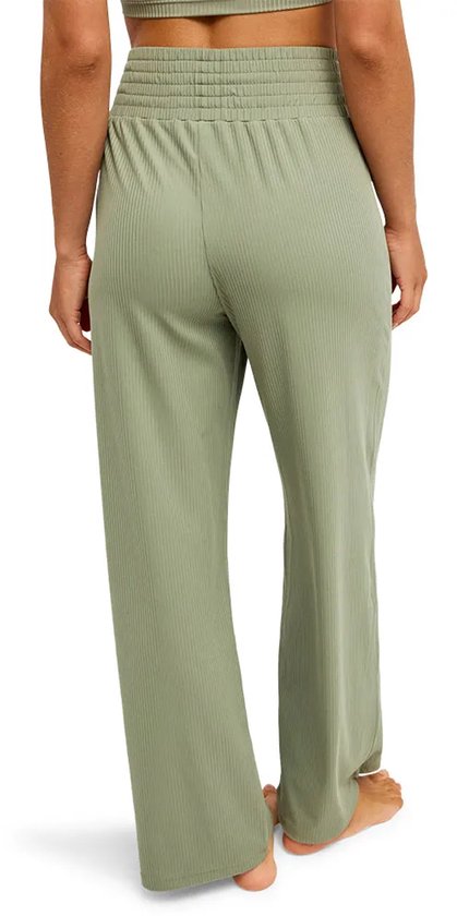 Lichtgroene, geribbelde broek met wijde pijpen en een elastische tailleband, gezien vanaf de achterkant.