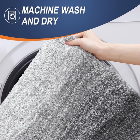 Zachte grijze badmat wordt in een wasmachine geplaatst met de tekst 'MACHINE WASH AND DRY'.